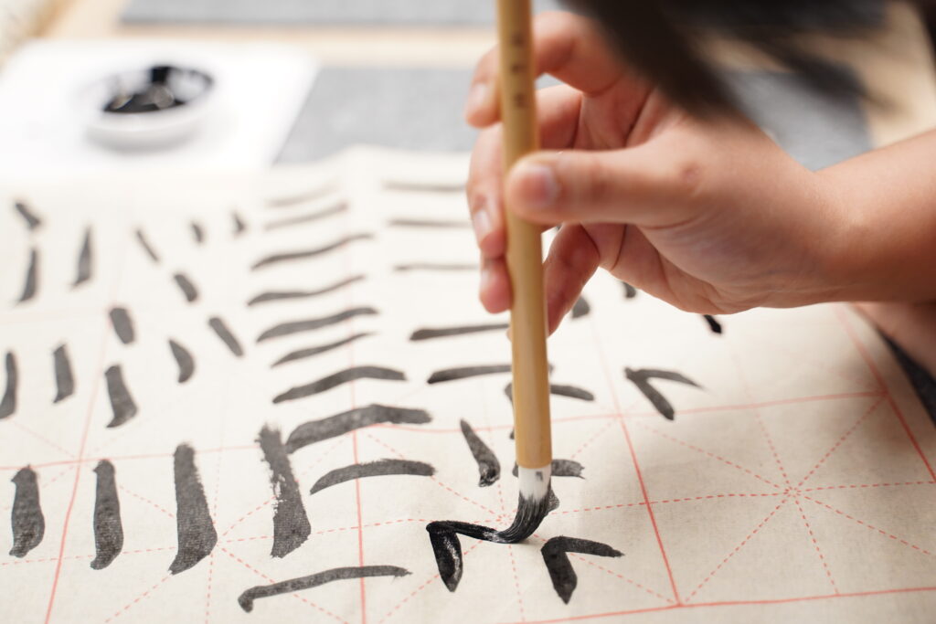 Some close ups of our SITizen practicing the strokes and dots of the Chinese characters.