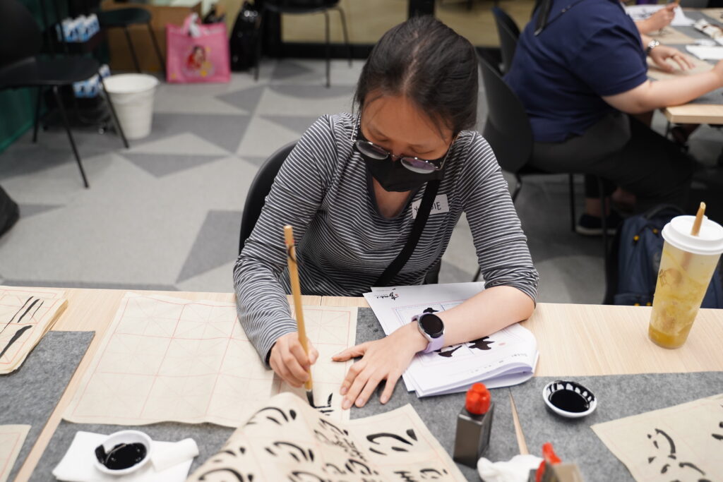Some close ups of our SITizen practicing the strokes and dots of the Chinese characters.