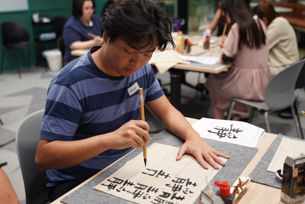 Some close ups of our SITizen practicing the strokes and dots of the Chinese characters.