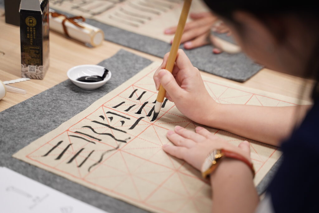 Some close ups of our SITizen practicing the strokes and dots of the Chinese characters.